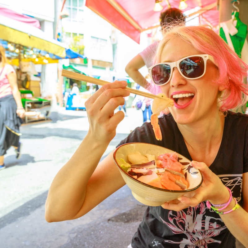 Woman Tourist Eating Food In Japan