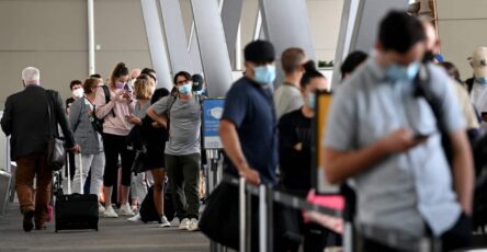 People wait in a queue at an airport terminal