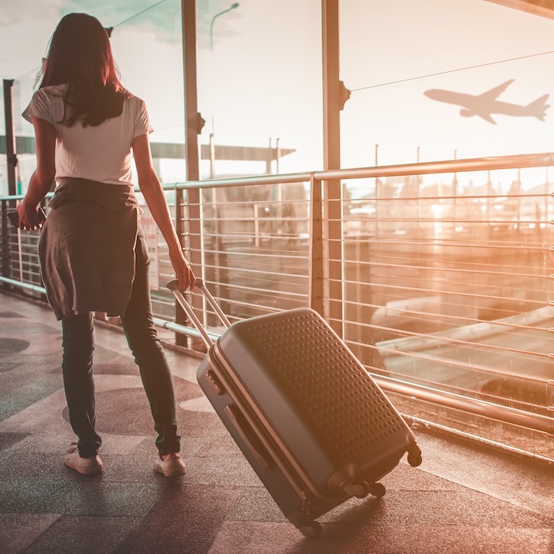 Woman Walking With Suitcase At Airport